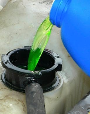 pouring coolant into engine