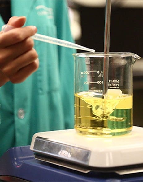 lab tech with beaker of fluid